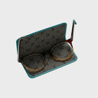 Pair of glasses on a grey luxury glasses case lining with teal leather border