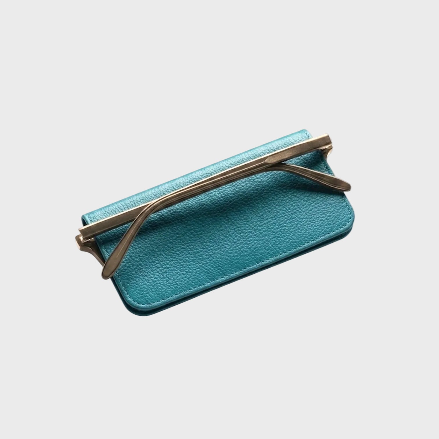 Teal flat  lasses case with gold sunglasses on a white background
